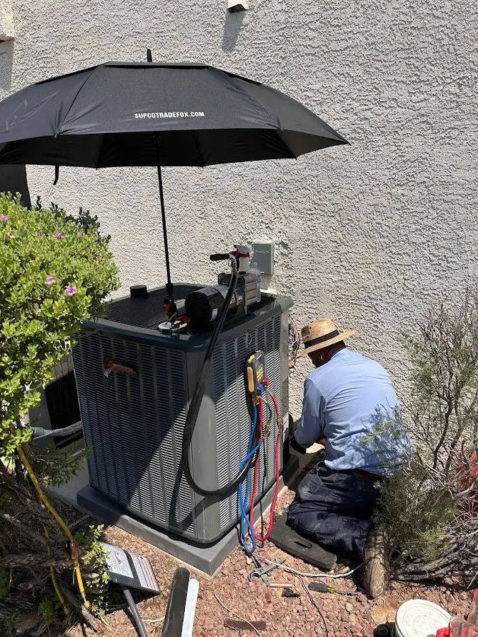 HVAC technician performing outdoor AC maintenance in Edgemere