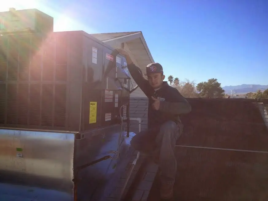 HVAC technician performing HVAC Inspection on a rooftop unit in Edgemere